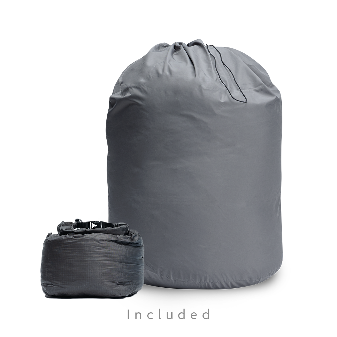Two gray storage bags for a backpacking quilt: a large drawstring long-term storage sack and a smaller compressible stuff sack.